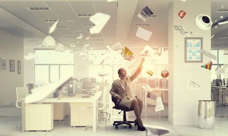 Young businesswoman sitting in chair and reaching handの写真素材