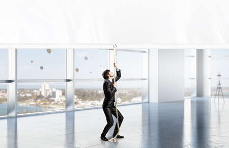 Young businessman in office and blank banner. Place for textの写真素材