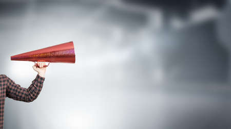 Hand of guy in shirt make announcement in trumpetの写真素材