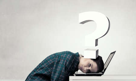 Woman programmer pressed with question mark to laptop