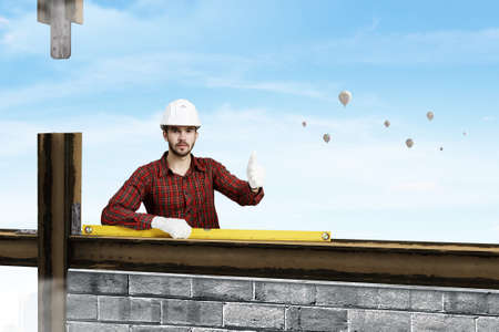 Builder man in checked shirt using measuring level