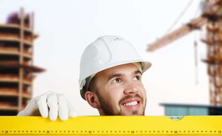 Builder man in checked shirt using measuring level