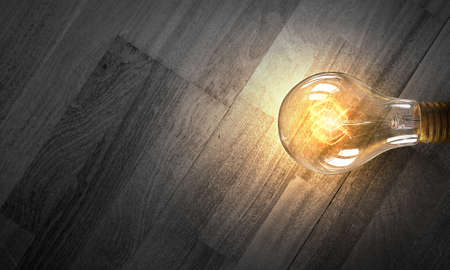 Power and energy concept with light bulb on wooden surfaceの写真素材