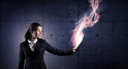 Young businesswoman holding tablet on dark backgroundの写真素材