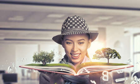 Young hipster girl with opened book in hands
