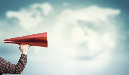Hand of guy in shirt make announcement in trumpetの写真素材