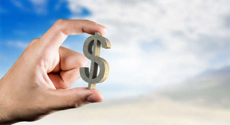 Tiny dollar currency sign holden between fingers