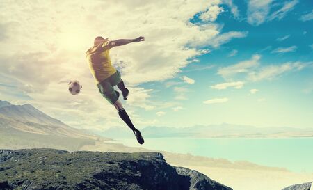 Shoot of football player on the top of rock