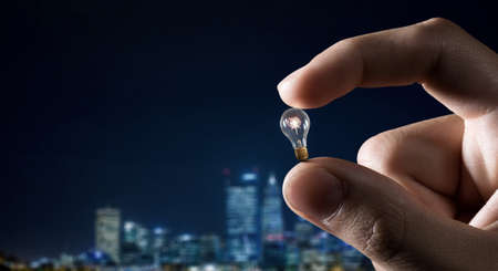 Male hand taking with fingers light bulb