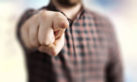 Close up of a man in checked shirt pointing with finger at cameraの写真素材