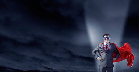 Young confident super businessman in mask and capeの写真素材