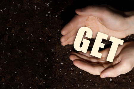 Male hands on soil background showing in palms business conceptual wordの写真素材