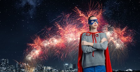 Young confident woman in red cape and maskの写真素材