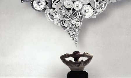 Young relaxed businesswoman sitting relaxed in chair and thinking something overの写真素材