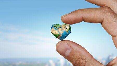 Small Earth planet between male fingers.の写真素材