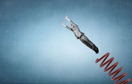Businessman jumping on springboard as progress conceptの写真素材
