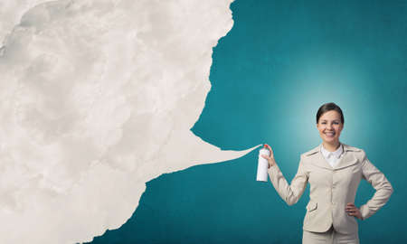 Young elegant businesswoman with white spray balloon in handの写真素材