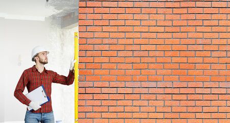 Builder man in checked shirt using measuring levelの写真素材