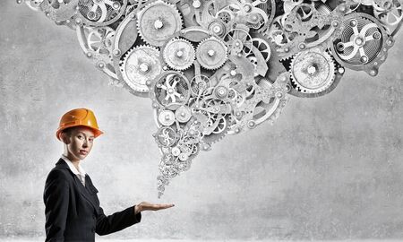 Young engineer woman reaching hand with gears flying outの写真素材