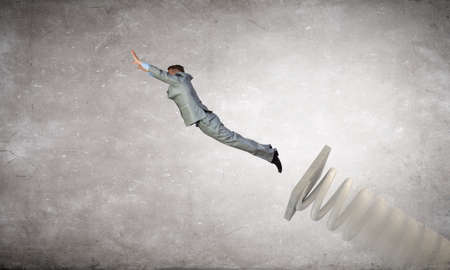 Businessman jumping on springboard as progress conceptの写真素材