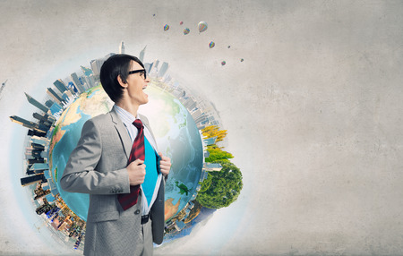 Young businessman acting like super hero and tearing his shirt off. Elements of this image are furnished by NASAの写真素材