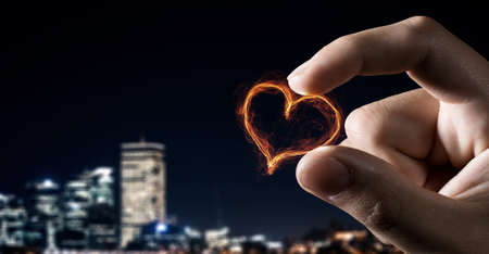 Close view of male hand taking with fingers glowing love symbolの写真素材