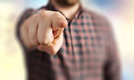 Close up of a man in checked shirt pointing with finger at cameraの写真素材