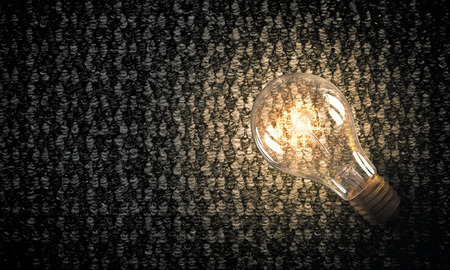 Power and energy concept with glass glowing light bulb o backdrop