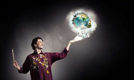 Young handsome man painter with brush in hand. Elements of this image are furnished by NASA