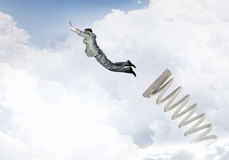 Businessman jumping on springboard as progress concept