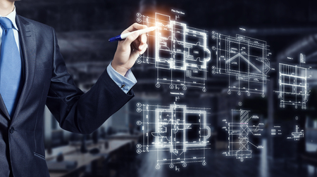 Male architect working with virtual construction planの写真素材