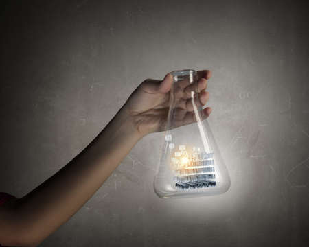 Male hand shows flask with 3D cube illustration insideの写真素材