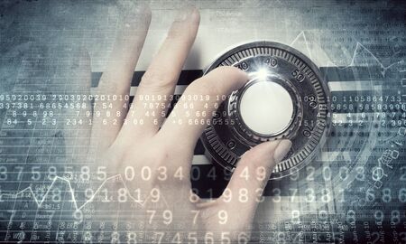 Hands of woman dialing numbers on safe padlock