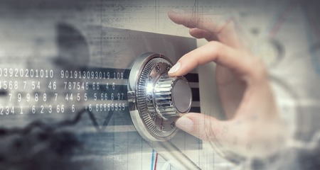 Hands of woman dialing numbers on safe padlockの写真素材