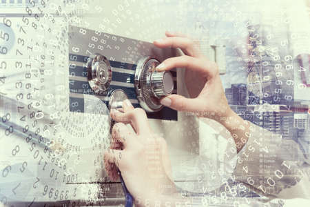 Hands of woman dialing numbers on safe padlockの写真素材