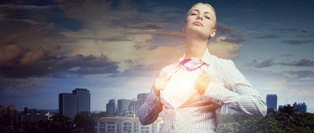 Businesswoman opening her shirt on chest like superheroの写真素材