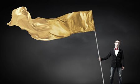 Young student guy with color blank waving flagの写真素材