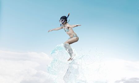 Kid girl in diving mask jumping in waterの写真素材