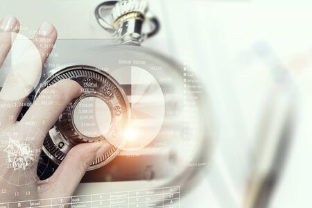 Hands of woman dialing numbers on safe padlockの写真素材