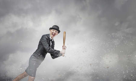 Young pretty woman in suit and hat with baseball bat