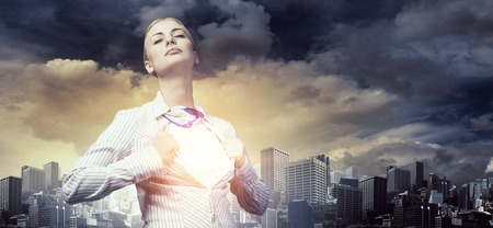 Businesswoman opening her shirt on chest like superheroの写真素材