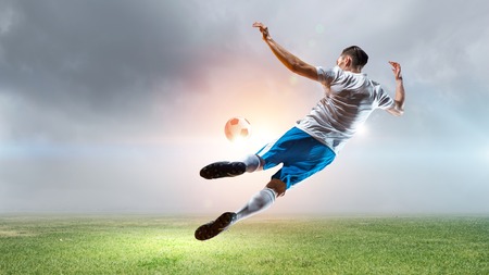 Football player with ball in action at stadium