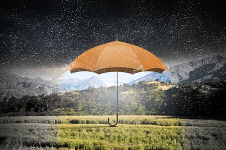 Conceptual image with color umbrella in sky under rainの写真素材
