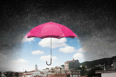 Conceptual image with color umbrella in sky under rainの写真素材