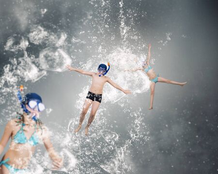 Kid boy in diving mask making jump in to water