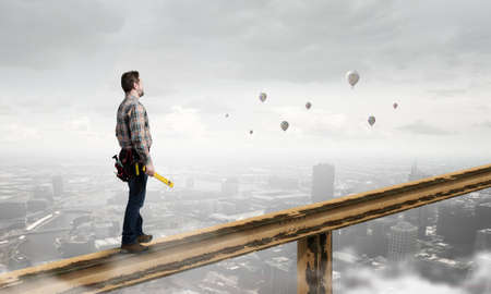 Builder man in checked shirt with tool belt on waist