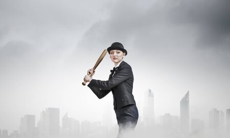 Young pretty woman in suit and hat with baseball batの写真素材