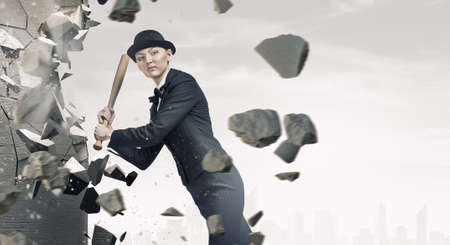 Young pretty woman in suit and hat with baseball batの写真素材
