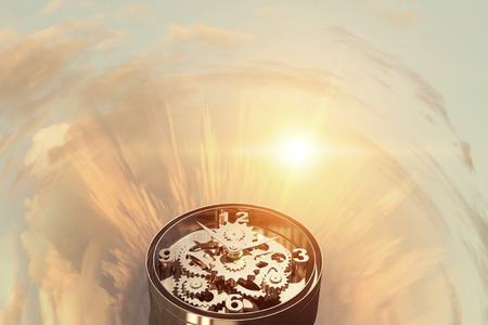 Time concept with old clock mechanism against sky backgroundの写真素材