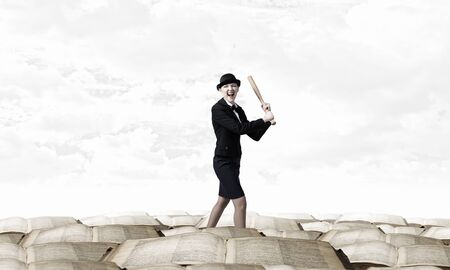 Young pretty woman in suit and hat with baseball batの写真素材